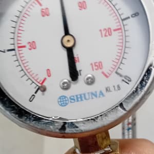 מד לחץ מים עם יד אוחזת בו