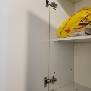 צירי מתכת על דלת ארון לבנה