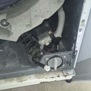 חלקים פנימיים של מכונת כביסה עם צינורות וחיבורים חשמליים