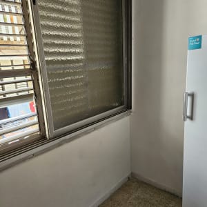 קיר צבוע בלבן ליד חלון עם תריסים