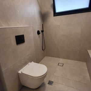 חדר אמבטיה עם שירותים ומקלחת מודרניים