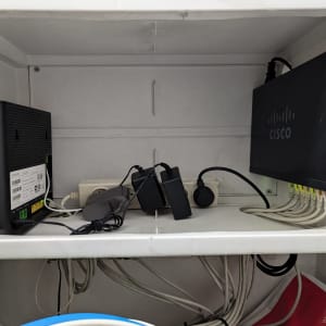 נתב סיסקו ומודם טכניקולור מחוברים לכבלים בארון תקשורת