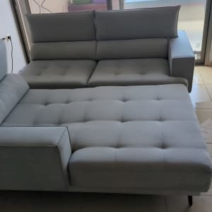 ספת בד אפורה נקייה בסלון לאחר עבודת ניקוי ספות