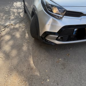 רכב כסוף עם פגוש קדמי פגום על כביש אספלט