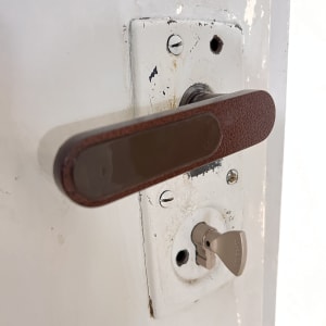 מנעול דלת עם ידית חומה ומפתח מוכנס