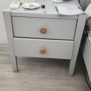 שולחן קטן עם בקבוק מים, שעון מעורר ומנורה