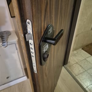 מנעול דלת עם ידית שחורה על דלת עץ