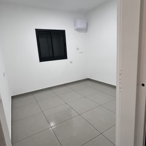 חדר ריק עם רצפה נקייה וחלון קטן