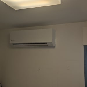 מזגן מותקן על קיר בחדר עם תמונות