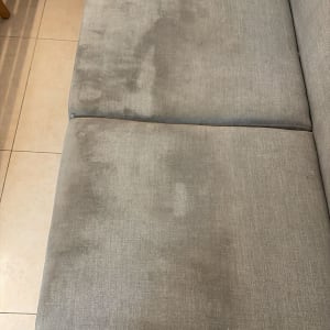 ספה אפורה עם כתמים על הריפוד