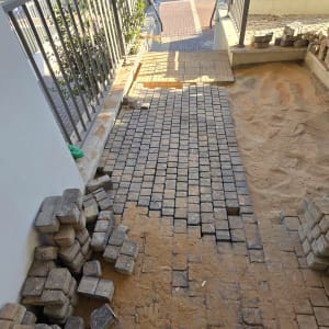 אבנים משתלבות מונחות על שביל עם חול