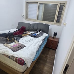 כלים וחומרים על מיטה בחדר שינה, קירות צבועים