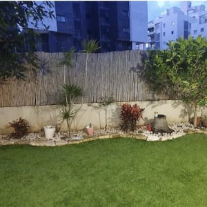 גינה עם דשא מלאכותי, עציצים ואבנים דקורטיביות