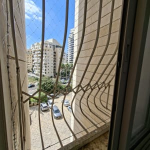 רשת בטיחות על חלון עם נוף לבניינים