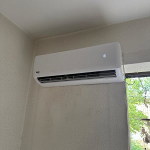 מזגן מותקן על קיר פנימי ליד חלון