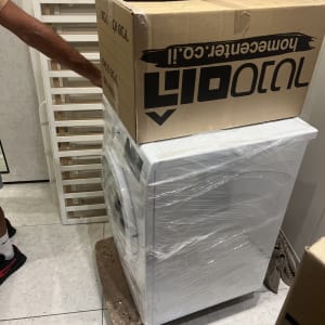 מכונת כביסה עטופה בניילון על עגלת הובלה
