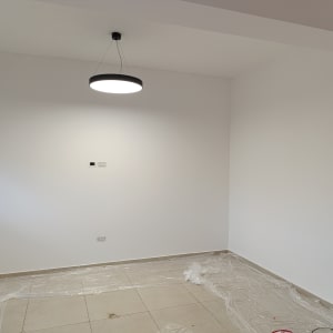 קיר צבוע בלבן עם ניילון על הרצפה