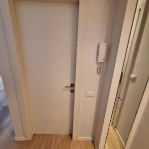 דלת לבנה עם ידית מתכת ומנעול