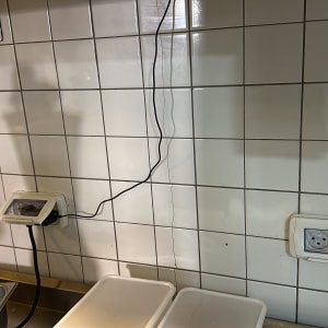 שקעים חשמליים על קיר אריחים עם חוטים מחוברים
