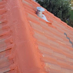 גג רעפים כתום עם צינור מתכת קטן