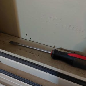 מברג מונח על מסגרת חלון, כלי עבודה לתריסים