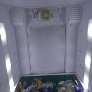 מאוורר ומדפים במקרר עם מוצרים ארוזים