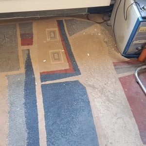 מאוורר ומחשב על שטיח צבעוני עם לכלוך