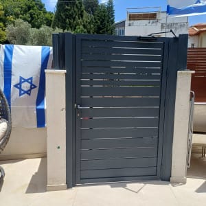 שער אלומיניום עם דגלי ישראל ברקע