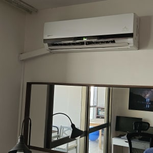 מזגן קיר לבן מותקן על הקיר בחדר