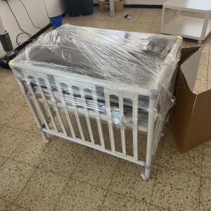 עריסה עטופה בניילון בחדר עם רהיטים