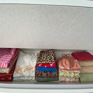 מגירת בגדים מסודרת עם חולצות צבעוניות ומקופלות