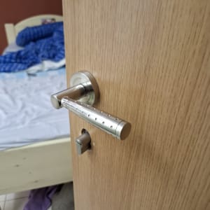 ידית דלת מתכתית על דלת עץ