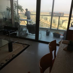 אדם מנקה חלון במרפסת עם דלי ומגב