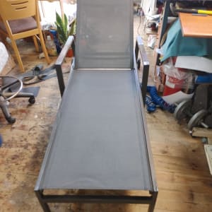 כיסא נוח עם ריפוד אפור על רצפת עץ