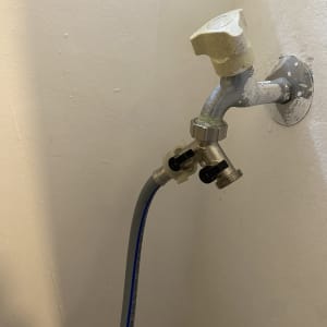 ברז מים עם צינור מחובר לקיר