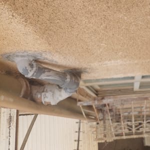 צינור אפור מחובר לקיר עם חיבורים נוספים