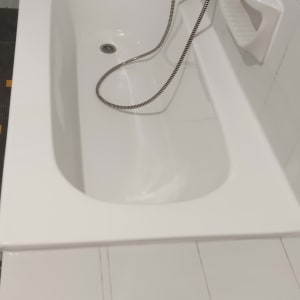 אמבטיה לבנה עם ברז ומקלחת יד