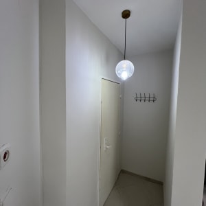 מסדרון עם דלת, מנורה וקולב על הקיר