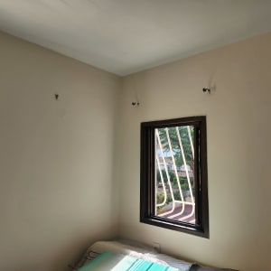 קיר צבוע בצבע בהיר עם חלון קטן