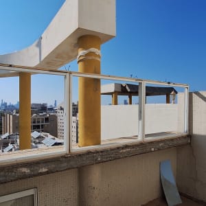 עמודים צהובים ומסגרת חלון ללא זכוכית על גג