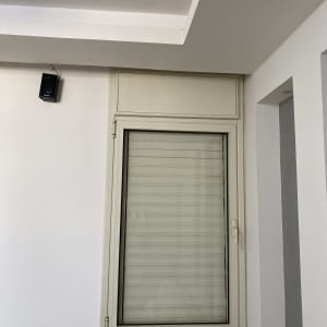 חלון עם תריסים סגורים על קיר לבן