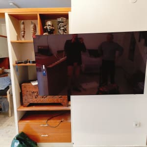 טלוויזיה מותקנת על קיר, מדף עם כלי עבודה