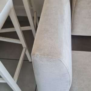 ספה בצבע בהיר ליד כיסאות לבנים
