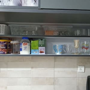 מדף מטבח עם קופסאות, כוסות וסלסלות פלסטיק