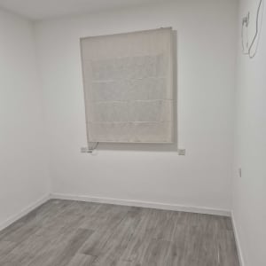 חדר ריק עם קירות לבנים ורצפת עץ