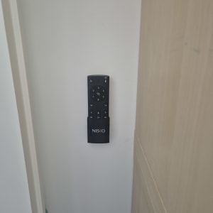 שלט רחוק על קיר לבן ליד דלת