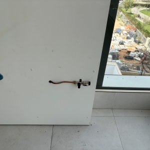 ברז מתכת עם ידית אדומה על קיר לבן