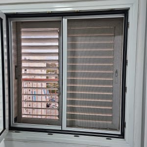 חלון אלומיניום עם תריסים פתוחים למחצה