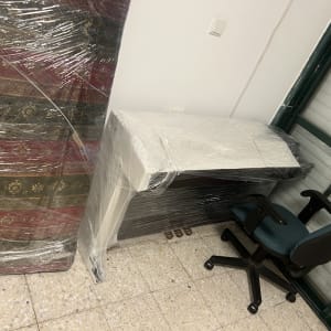 רהיטים עטופים בניילון בחדר עם כיסא משרדי