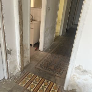 קירות עם סימני רטיבות, רצפה מעוטרת, כיור במבט צד